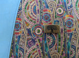 Colorful patterned fabric with a tree of life emblem on a blue background