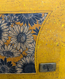 Close up Yellow cork handbag with blue daisy pattern and tree of life emblem